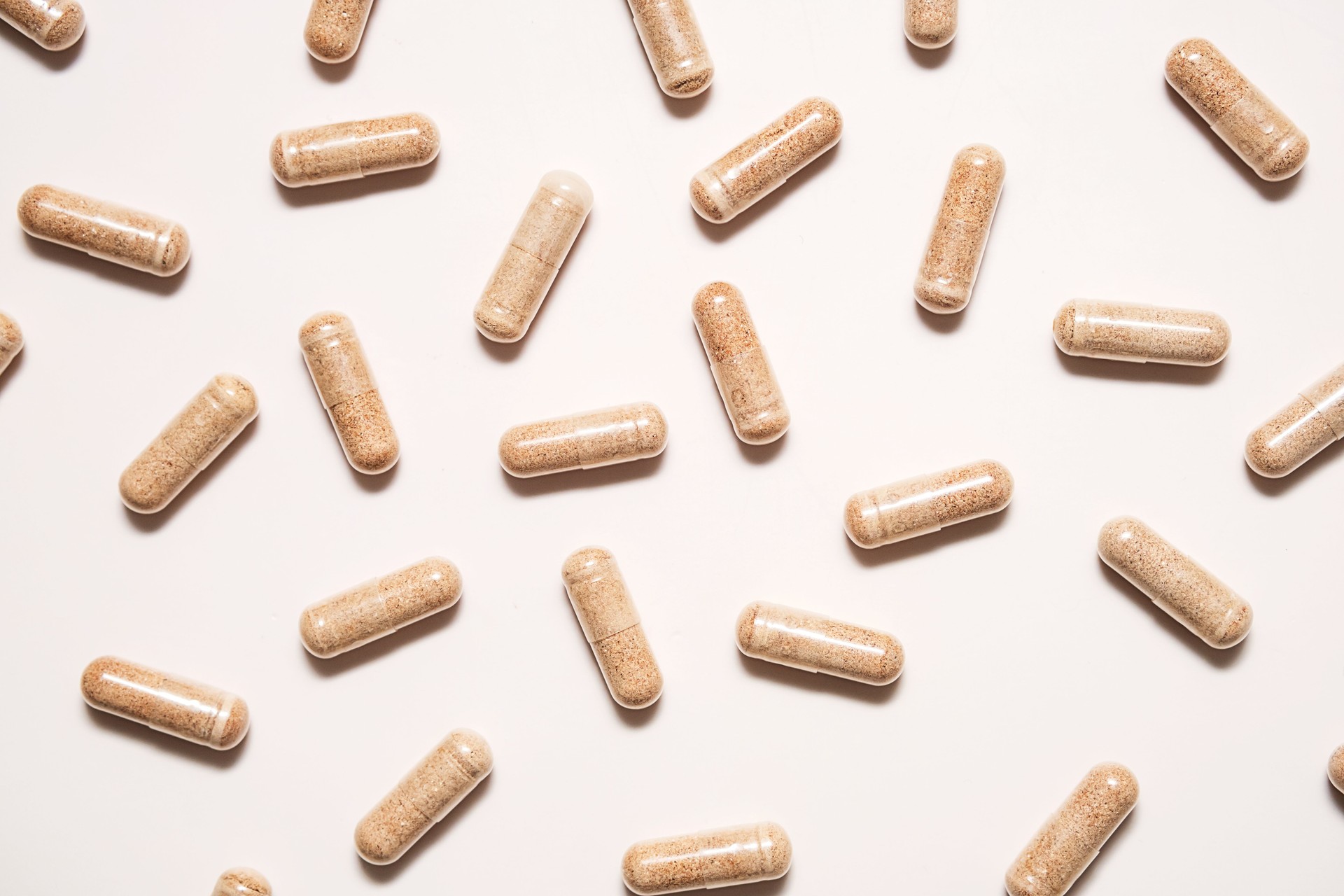 Vitamin capsules on neutral background.